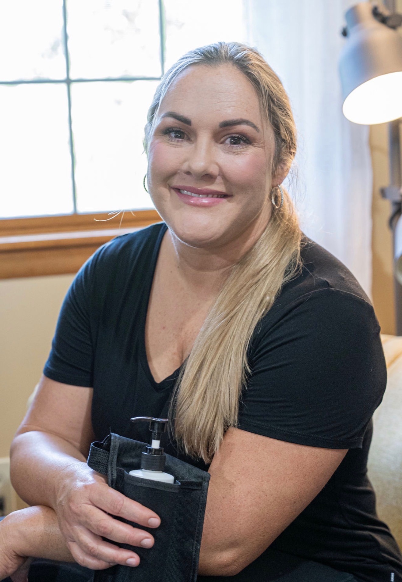 Jenn Giannotti, licensed massage therapist, holding her massage oil at her studio in Emmaus, PA